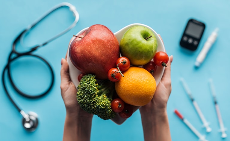 frutta e verdura fresca, sullo sfondo dispositivi medici per il diabete