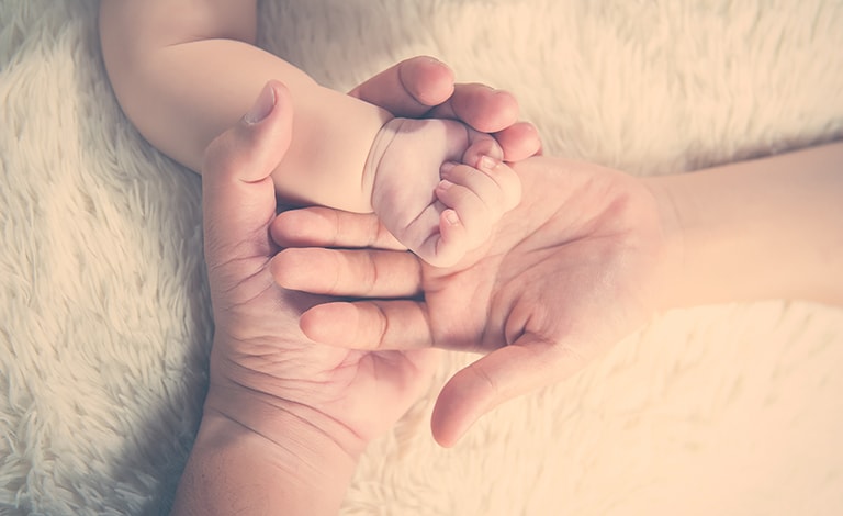 mani adulte con mano di neonato