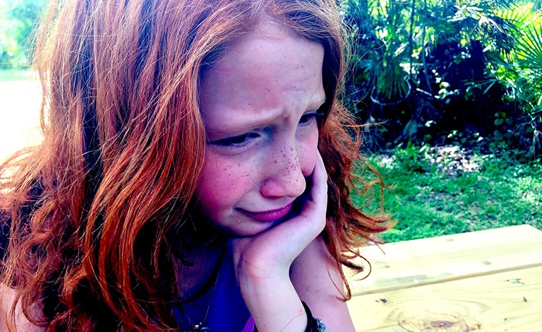 bambina che piange in un giardino